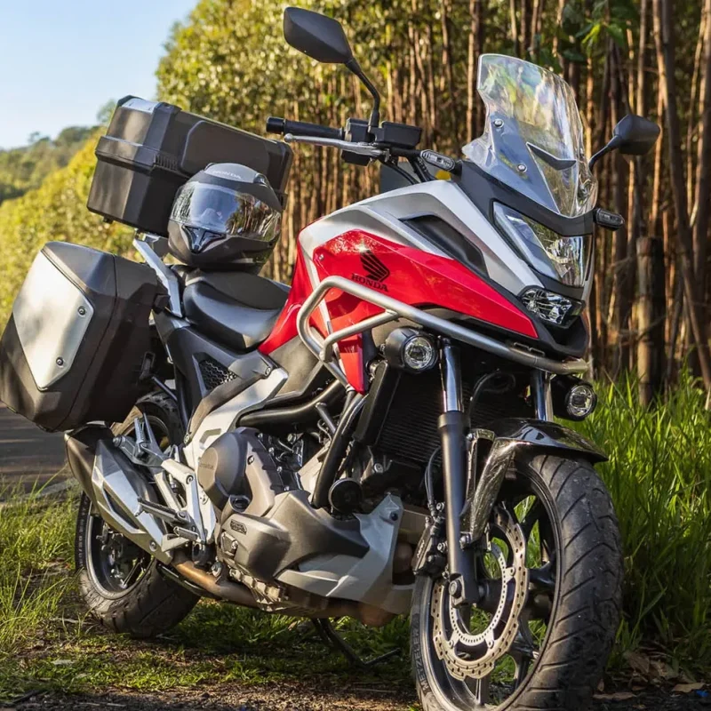 moto-honda-nc-750x-vermelho-estacionada-em-gramado-ao-lado-da-estrada